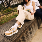 Femme portant des sneakers vegan unisexes beige et noir