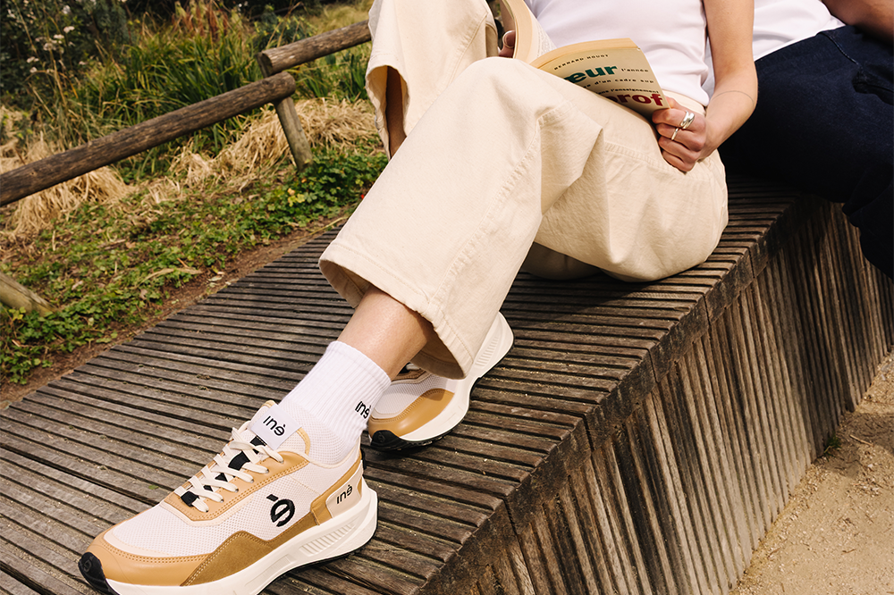 Femme portant des sneakers vegan unisexes beige et noir