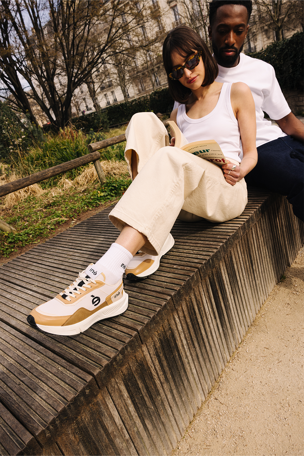Femme portant des sneakers vegan unisexes beige et noir