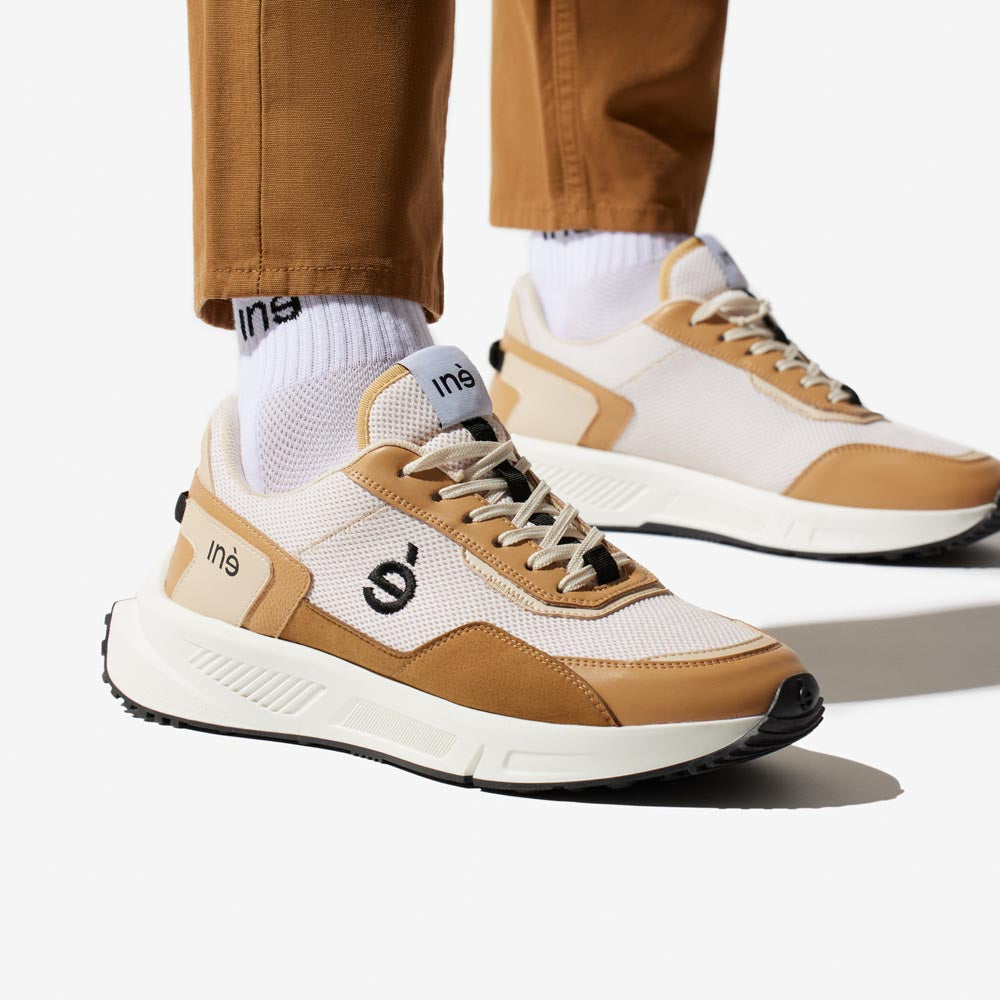 Sneakers vegan unisexes beige et noir et pantalon marron