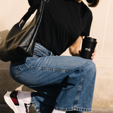 Femme portant des baskets vegan unisexes bordeaux et noir de la marque iné, disponibles du 36 au 46