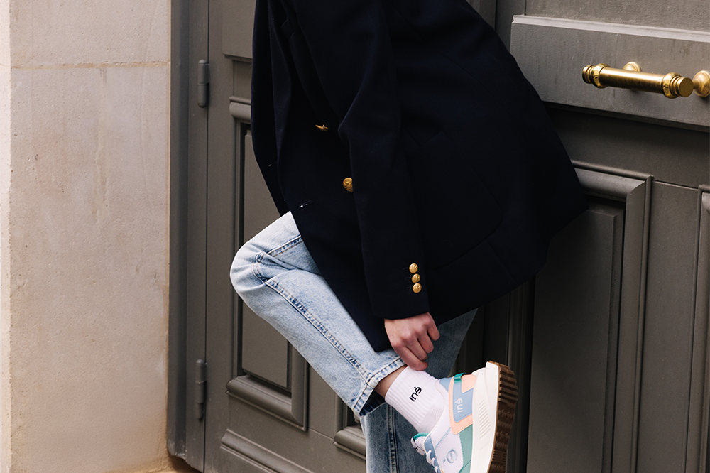 Femme portant des sneakers vegan unisexes corail et bleu pastel
