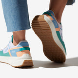 Sneakers vegan unisexes corail et bleu pastel et un jean