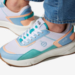 Sneakers vegan unisexes corail et bleu pastel et un jean
