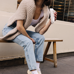 Femme portant des sneakers crème et jaune de la marque iné, unisexes et disponibles du 36 au 46