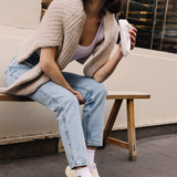 Femme portant des sneakers crème et jaune de la marque iné, unisexes et disponibles du 36 au 46