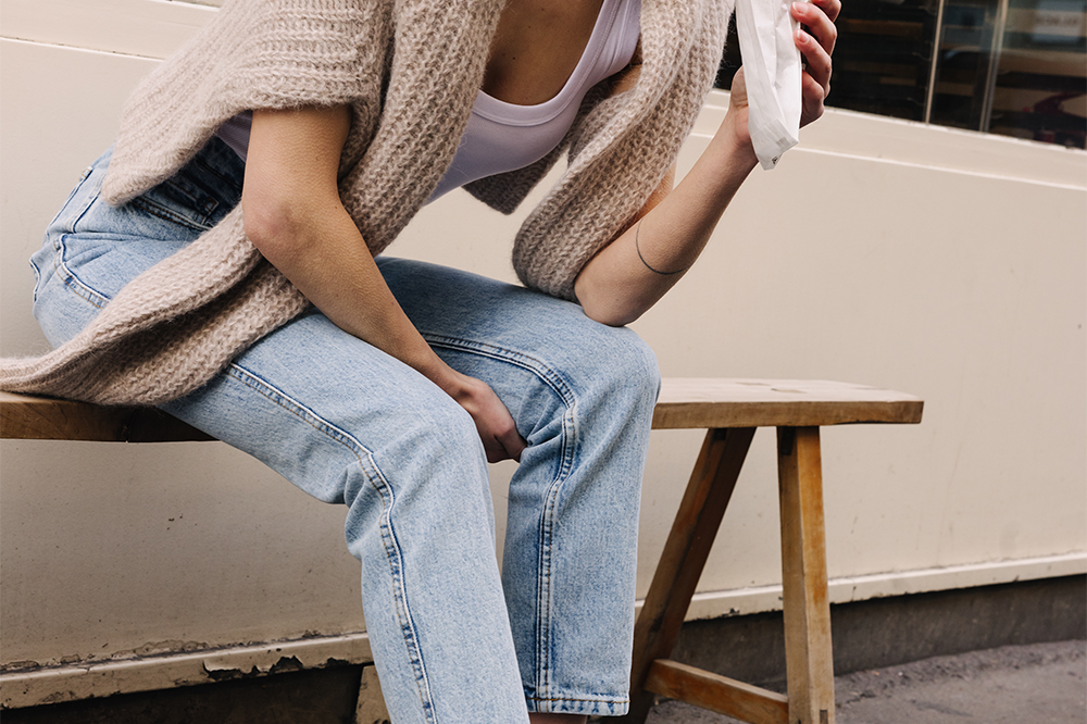 Femme portant des sneakers crème et jaune de la marque iné, unisexes et disponibles du 36 au 46