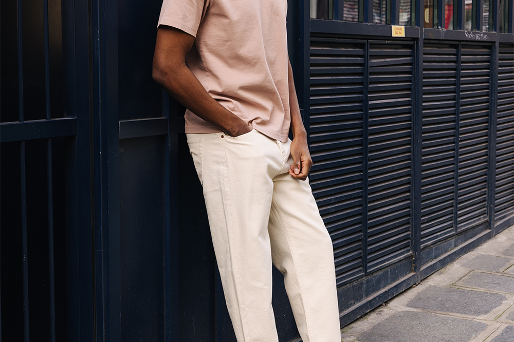 Homme portant des sneakers crème et jaune de la marque iné, unisexes et disponibles du 36 au 46
