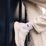 Homme portant des baskets crème et jaune et un pantalon beige de la marque iné, unisexes, disponibles du 36 au 46