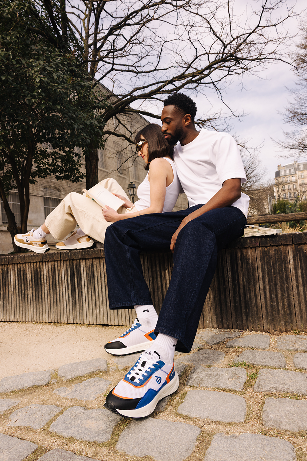 Couple Femme et Homme portant des sneakers orange et bleu et beige et noir

