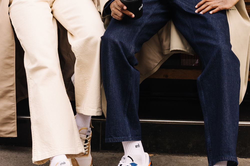 Couple Femme et Homme portant des sneakers orange et bleu et beige et noir de la marque iné, unisexes et disponibles du 36 au 46
